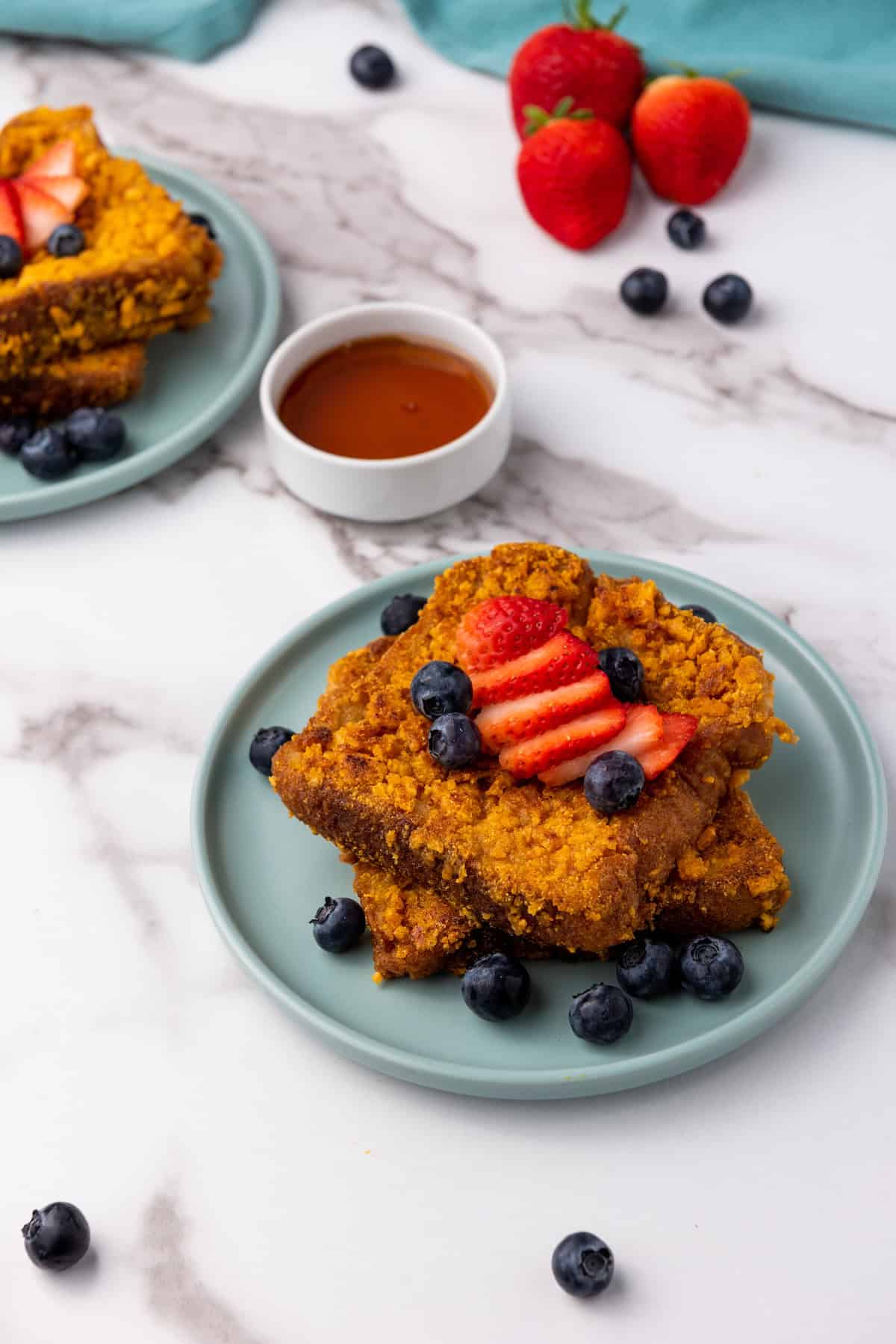 french toast on plate with strawberries and blueberries