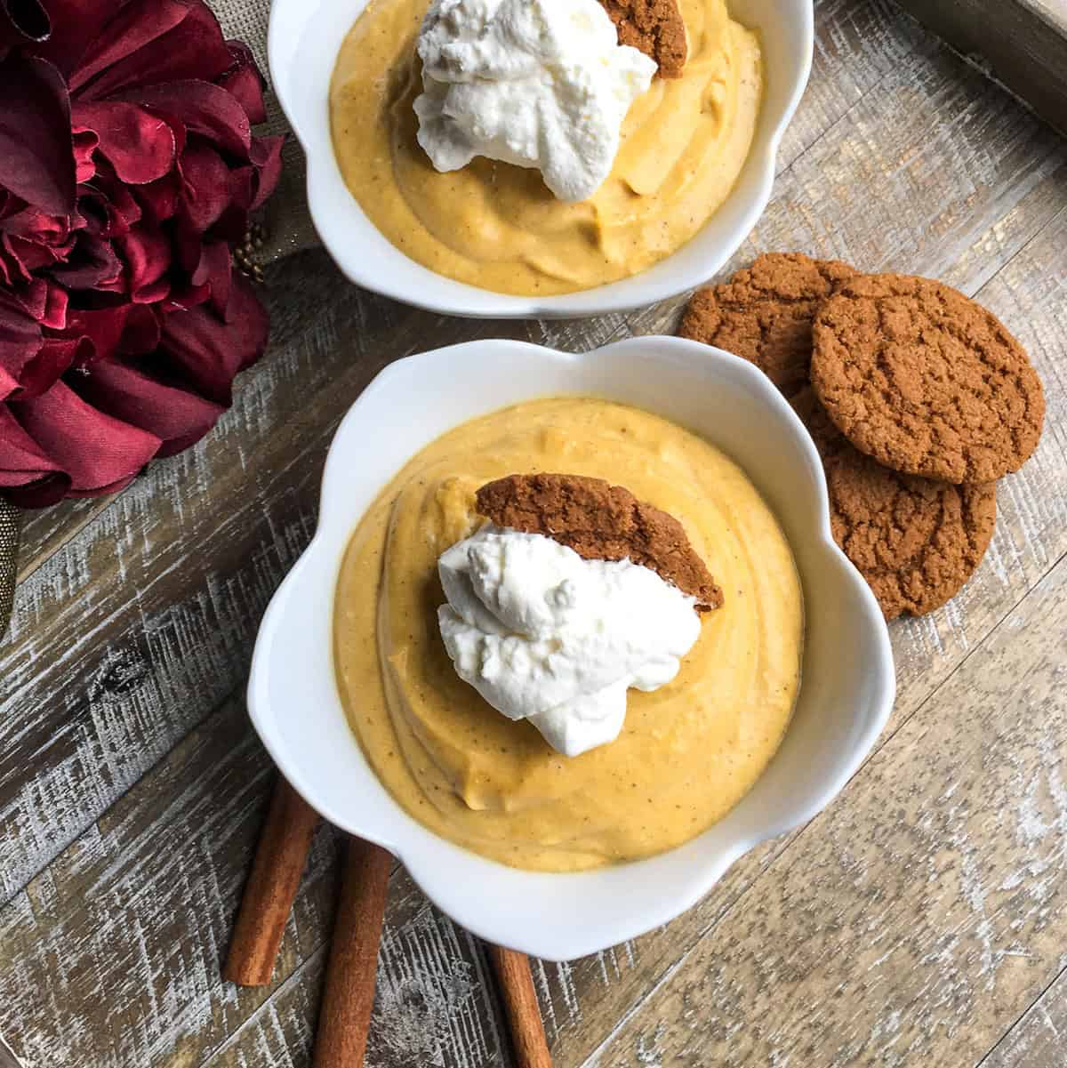 two bowls of pumpkin mousse with cookies and cinnamon