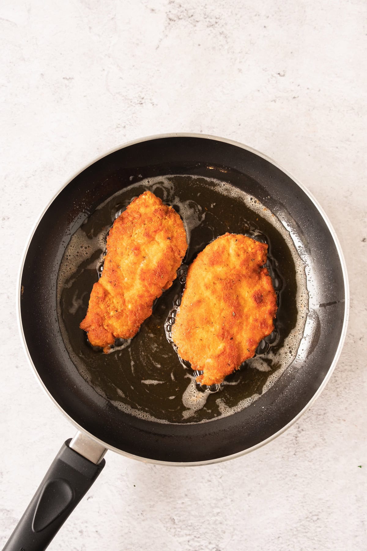 breaded chicken in frying pan