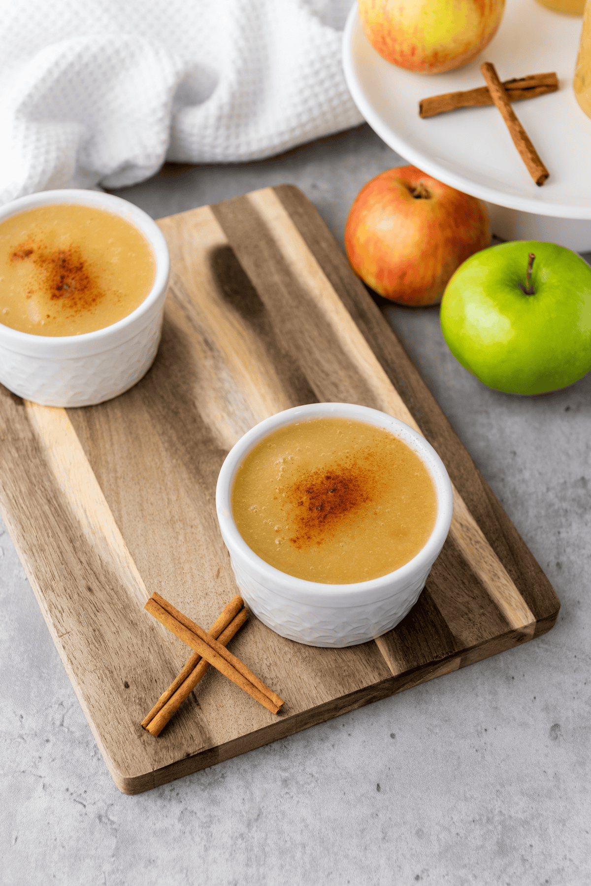 two cups of instant pot applesauce on cutting board